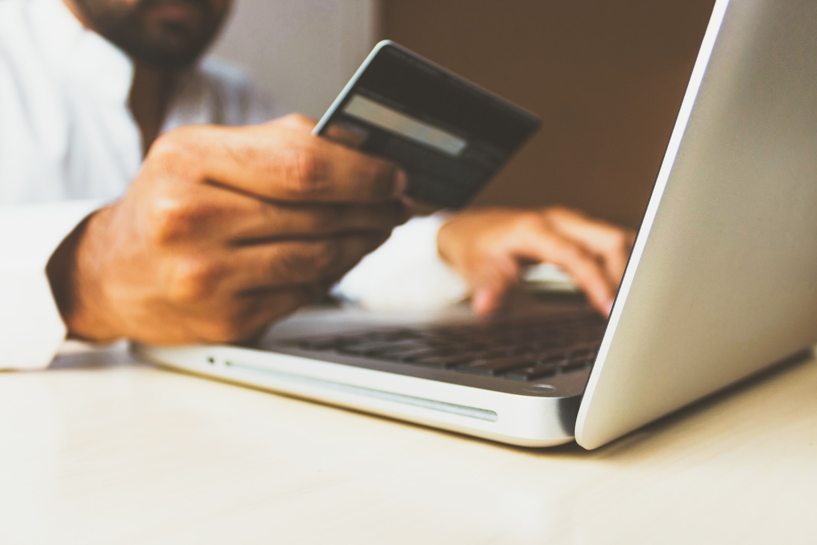 persona che utilizza un computer portatile con in mano una carta