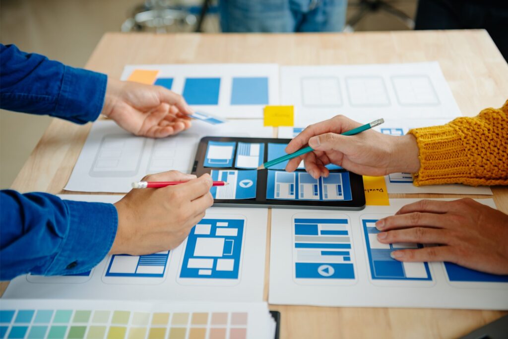 Mains travaillant sur des maquettes de site web avec une tablette