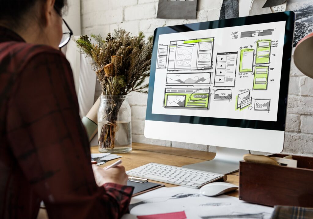 Person studying interface mock-ups on a computer screen.